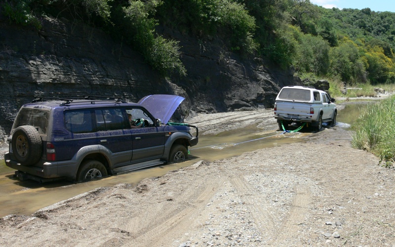 Getting a tow out of a muddy river bed.