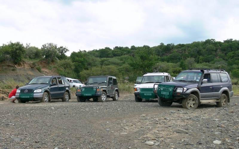 4 vehicles in a dry river bed.