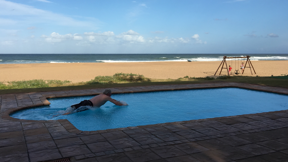 Kevin diving into the swimming pools with the ocean in the background.