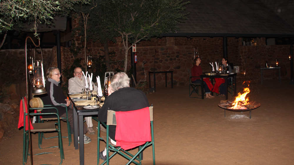 The boma area with a fire in the centre and tables around it.