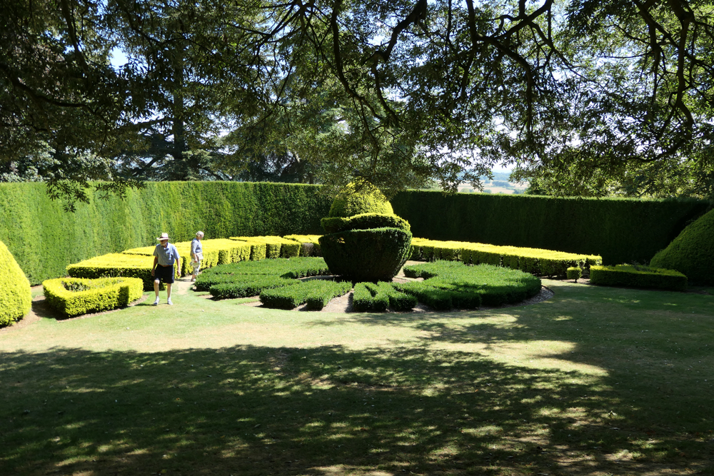 A formal area with clipped box hedges in the shape of a sundial.