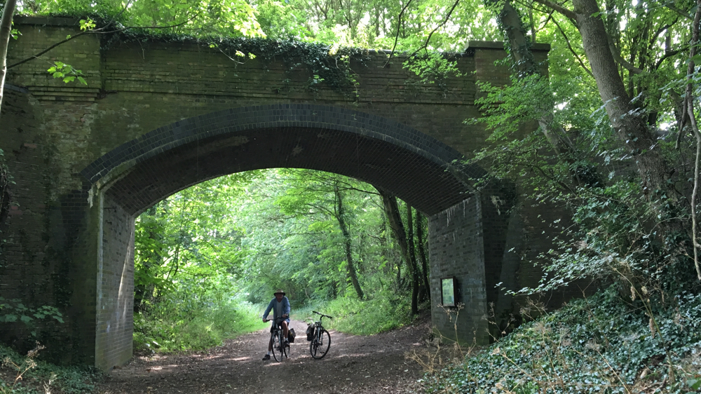 Kevin on his bike under an old railway bridge.