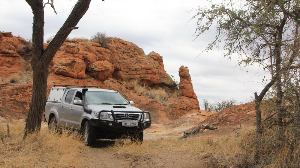 Our bakkie on the track near some sandstone cliffs.
