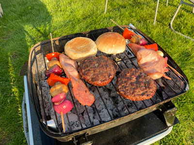 burgers, bacon, buns and skewers on the braai.