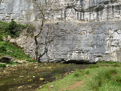  Malhan Beck appearing from a cave at the bottom of the cliff. 