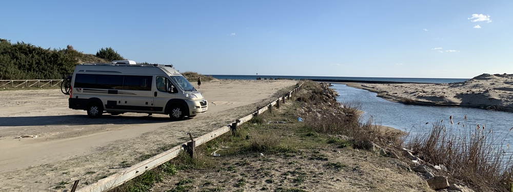 Parked next to a river with the sea in the distance