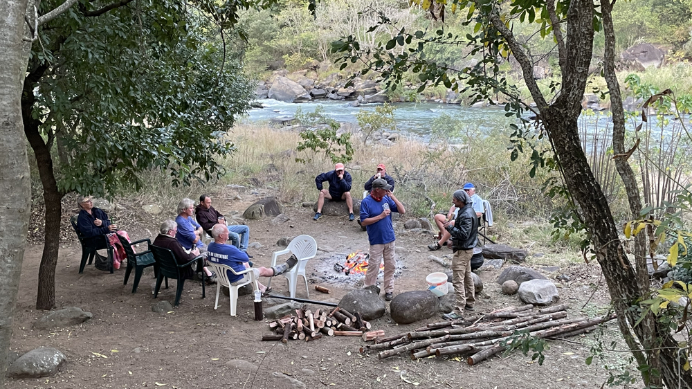 A dozen people around an open fire near the Umkomaas river.