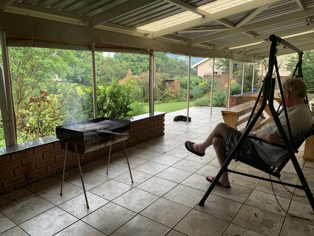 Kevin sitting on the swong on the veranda watcheing the braai.