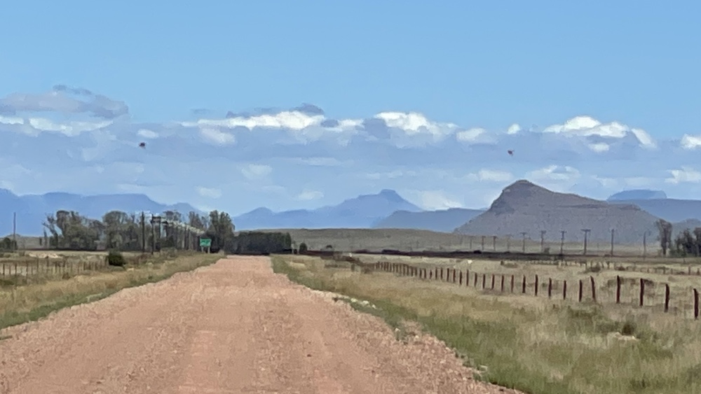 Gravel road with mountains in the distance.